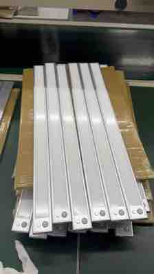 Finished aluminium light bars grouped at a factory workstation
