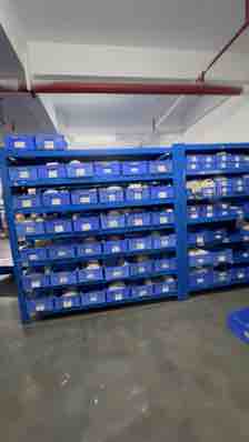 Blue parts bins beside a factory work area